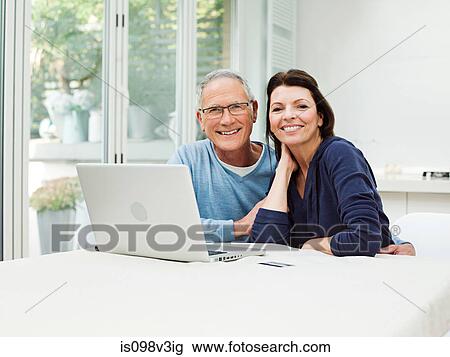 Mature couple using laptop with credit card View Large Photo Image Stock Image - Mature couple using laptop with credit card. Fotosearch