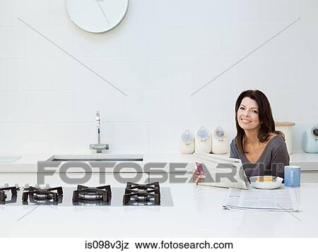 Mature woman having breakfast, reading newspaper View Large Photo Image Stock Photo - Mature woman having breakfast, reading newspaper. Fotosearch