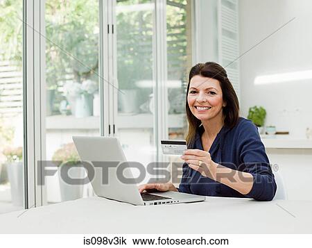 Mature woman using laptop with credit card View Large Photo Image Stock Image - Mature woman using laptop with credit card. Fotosearch