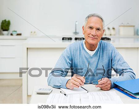 Stock Image - Senior man doing home finances. Fotosearch