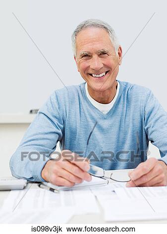 Stock Image - Senior man doing home finances. Fotosearch