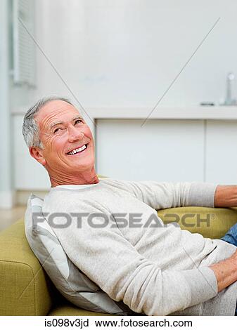 Senior man sitting on sofa View Large Photo Image Stock Image - Senior man sitting on sofa. Fotosearch