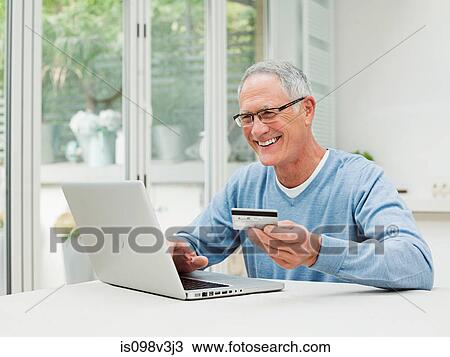 Senior man using laptop with credit card View Large Photo Image Stock Image - Senior man using laptop with credit card. Fotosearch