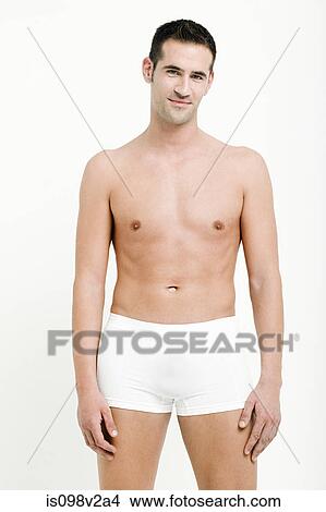 Picture - Portrait of young man wearing white boxer shorts. Fotosearch