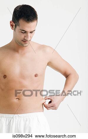 Young man pinching waist View Large Photo Image Picture - Young man pinching waist. Fotosearch