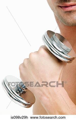 Stock Image - Young man with hand weights. Fotosearch