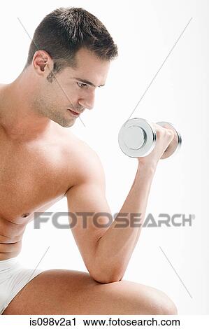Stock Image - Young man with hand weights. Fotosearch