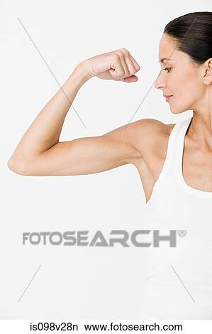 Young woman flexing muscles View Large Photo Image Picture - Young woman flexing muscles. Fotosearch