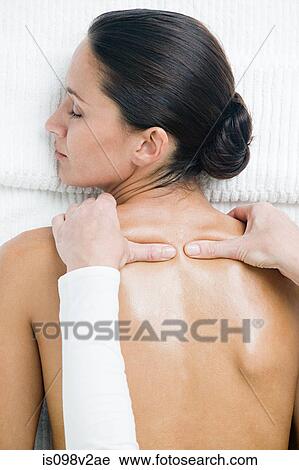 Stock Image - Young woman having shoulder massage. Fotosearch