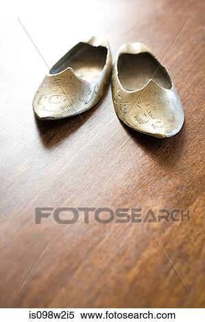 Stock Photography - Pair of ethnic slippers on wooden floor. Fotosearch