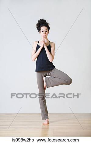 Woman in tree position during yoga View Large Photo Image Picture - Woman in tree position during yoga. Fotosearch