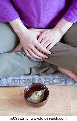 Woman sitting cross legged with teacup on floor View Large Photo Image Stock Photo - Woman sitting cross legged with teacup on floor. Fotosearch
