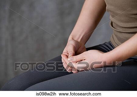 Stock Image - Woman with hands clasped, close up. Fotosearch
