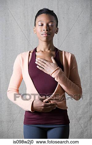 Stock Image - Women breathing deeply, touching chest and abdomen. Fotosearch