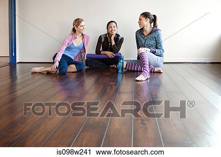 Three women sitting on gym floor View Large Photo Image Stock Image - Three women sitting on gym floor. Fotosearch
