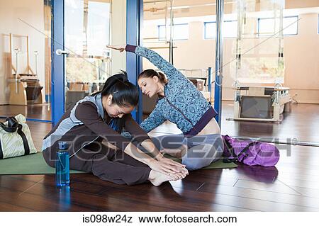 Stock Photo - Two woman stretching in gym. Fotosearch