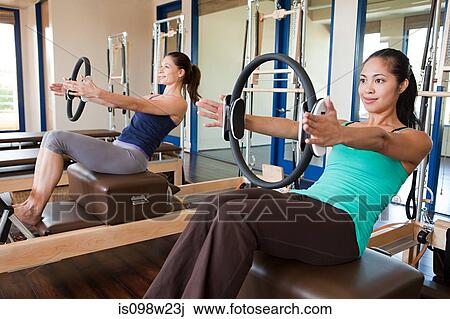 Stock Image - Two women doing pilates in gym. Fotosearch