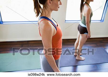 Stock Image - Two women doing yoga class. Fotosearch