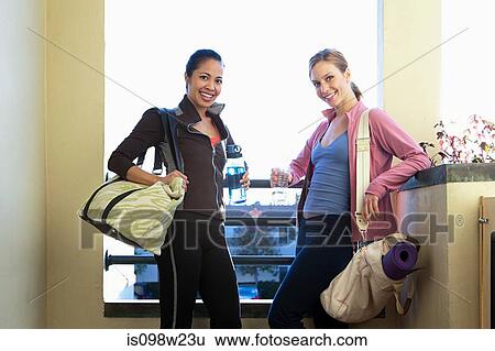 Stock Photograph - Two women with gym bags. Fotosearch