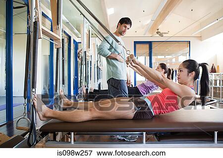 Stock Photo - Two women with pilates instructor. Fotosearch