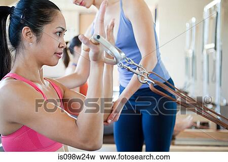 Woman doing bicep curls in pilates View Large Photo Image Stock Photo - Woman doing bicep curls in pilates. Fotosearch