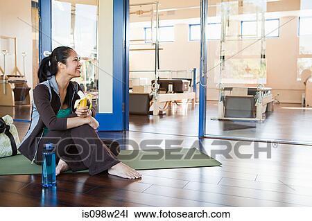 Woman eating banana in gym View Large Photo Image Stock Image - Woman eating banana in gym. Fotosearch