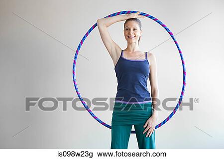 Stock Image - Woman holding plastic hoop doing pilates. Fotosearch