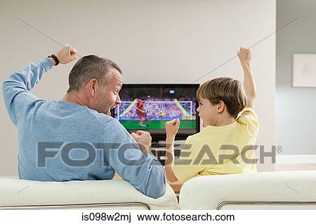 Father and son watching football on television View Large Photo Image Stock Image - Father and son watching football on television. Fotosearch