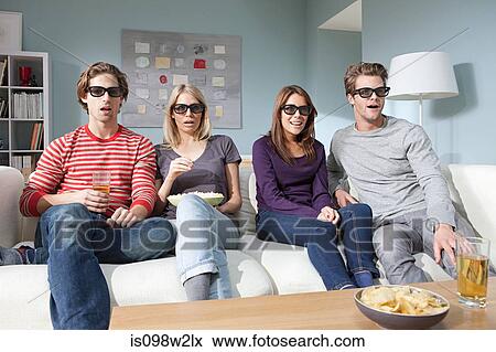 Stock Photo - Four friends watching 3d movie at home. Fotosearch