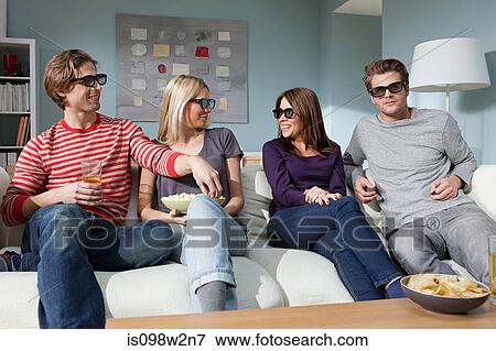 Stock Photo - Four friends watching 3d movie at home. Fotosearch