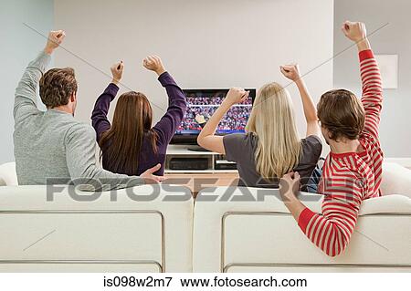 Four friends watching football on television View Large Photo Image Stock Photo - Four friends watching football on television. Fotosearch
