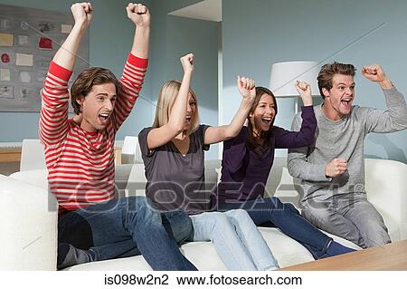 Four friends watching television cheering View Large Photo Image Stock Image - Four friends watching television cheering. Fotosearch