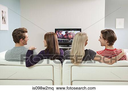 Two couples watching television View Large Photo Image Stock Photography - Two couples watching television. Fotosearch