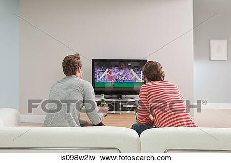 Two young men watching football on television View Large Photo Image Stock Photo - Two young men watching football on television. Fotosearch
