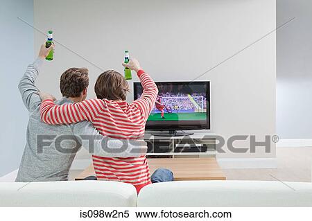 Stock Photography - Two young men watching football on television. Fotosearch