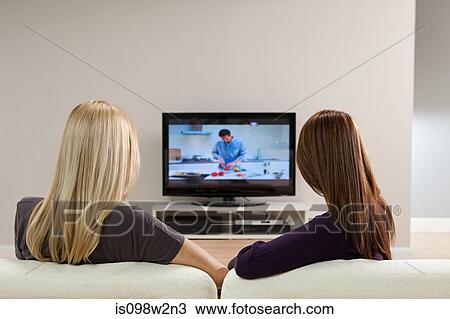 Stock Image - Two young women watching television. Fotosearch