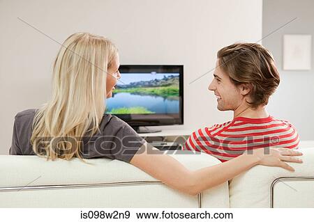 Young couple watching television View Large Photo Image Stock Photo - Young couple watching television. Fotosearch