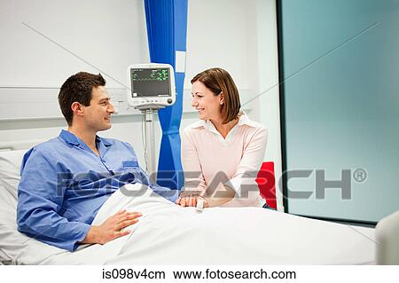 Picture - Wife visiting husband in hospital. Fotosearch