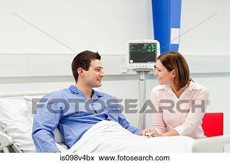 Stock Photo - Wife visiting husband in hospital. Fotosearch