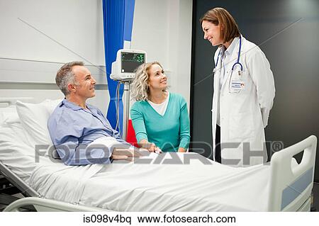 Wife visiting husband in hospital, talking to doctor View Large Photo Image Stock Photography - Wife visiting husband in hospital, talking to doctor. Fotosearch