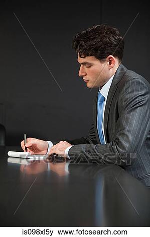 Stock Photo - Businessman in conference room making notes. Fotosearch