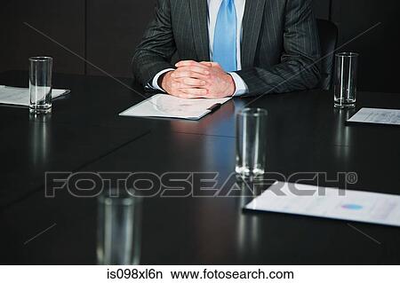 Picture - Businessman in conference room with documents. Fotosearch