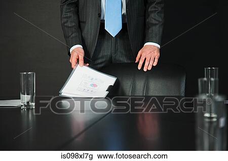 Stock Image - Businessman in conference room with documents. Fotosearch