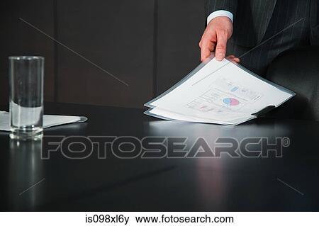 Stock Photo - Businessman in conference room with documents. Fotosearch