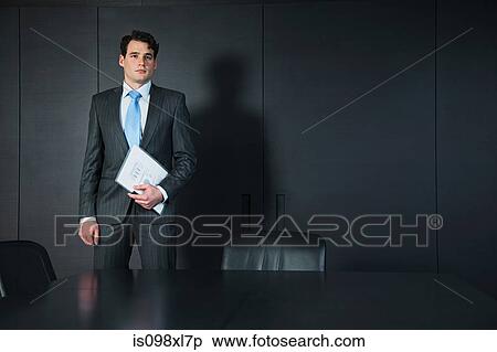 Stock Photography - Businessman in conference room with documents. Fotosearch
