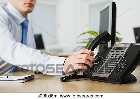 Picture - Office worker answering telephone. Fotosearch