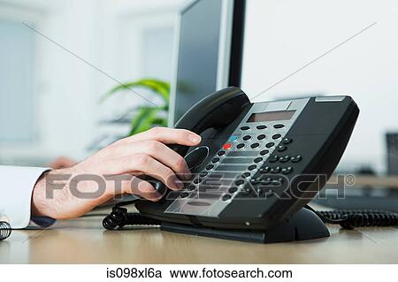 Stock Image - Office worker answering telephone. Fotosearch