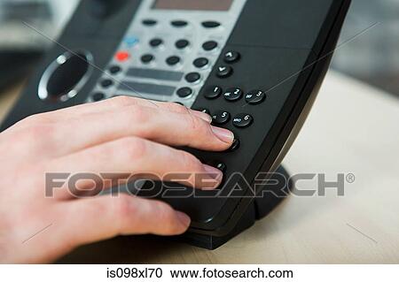 Office worker dialling on a landline phone View Large Photo Image Stock Image - Office worker dialling on a landline phone. Fotosearch