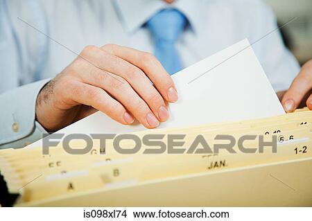 Picture - Office worker filing document. Fotosearch