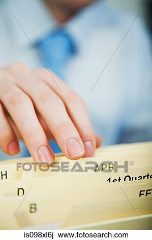 Stock Image - Office worker filing document. Fotosearch